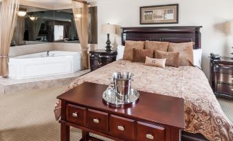 a luxurious bedroom with a king - sized bed and a jacuzzi in the middle of the room at Ramada by Wyndham High River