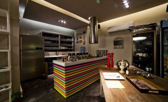 a modern kitchen with a colorful bar and stools , along with a stove and refrigerator at Upper House Hotel