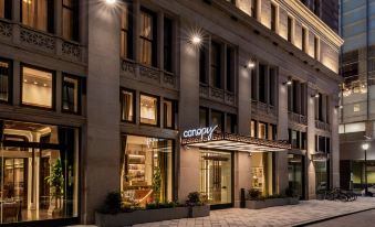 a large building with a neon sign above the entrance , illuminating the street at night at Canopy by Hilton Philadelphia Center City