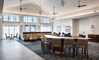 a large , open room with a long table and several chairs , along with several windows and ceiling fans at Homewood Suites by Hilton Newburgh-Stewart Airport