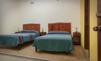 a hotel room with two beds , one on the left and one on the right side of the room at Donaji