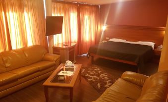 a spacious living room with a couch , chair , and bed in the center of the room at Green Hill Hotel