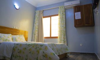 a cozy bedroom with a large bed , a window , and a door leading to a bathroom at Hotel Lewi