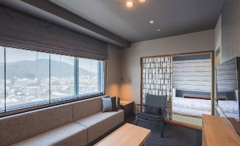 a modern living room with a couch , a chair , and a tv . the room is well - lit and has a view of the at Century Plaza Hotel