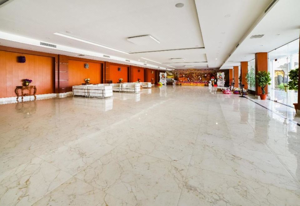 a large , empty lobby with white marble floors and orange walls , featuring a reception desk and several chairs at The Retreat