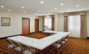 a large , empty conference room with multiple tables and chairs , set for meetings or events at Holiday Inn Express & Suites Jackson