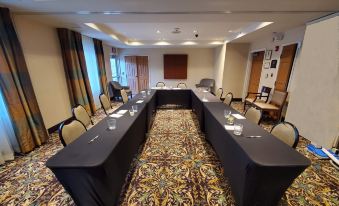 a conference room with a long table covered in a black tablecloth and several chairs arranged around it at Staybridge Suites Philadelphia Valley Forge 422