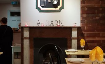 a dining area with a large dining table and chairs , as well as a fireplace in the background at Shellharbour Village Motel