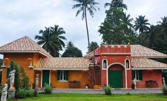 a beautiful orange house surrounded by lush green grass and palm trees , creating a picturesque scene at Cinque Terre Resort