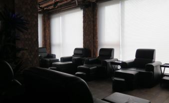 a room with black leather furniture , including couches and chairs , arranged in various positions and locations at ABC Hotel