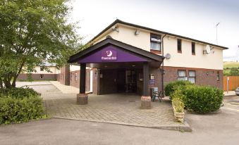 "a building with a purple sign that says "" premier inn "" and an open carport entrance" at Premier Inn Caerphilly (Corbetts Lane)