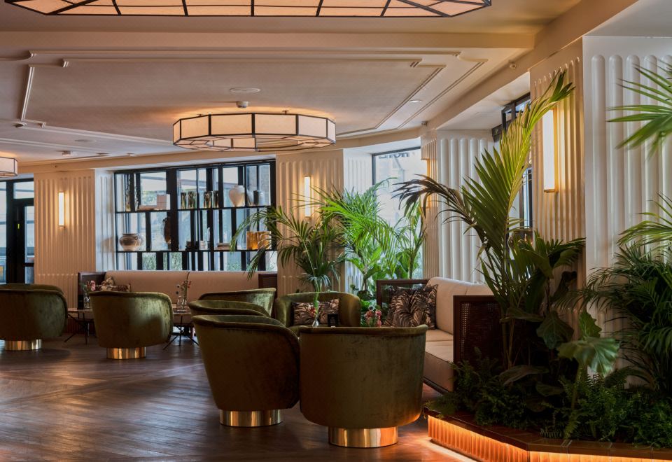 a modern , elegant living room with wooden floors , white walls , and large windows , featuring comfortable seating arrangements and potted plants at Only YOU Hotel Valencia