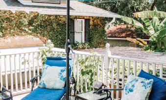 a blue and white patio set with an umbrella , lounge chairs , and a dining table at Park Place Inn and Cottages