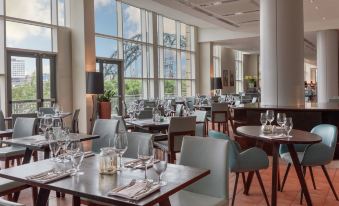 a large , well - lit dining room with multiple tables and chairs arranged for guests to enjoy a meal at Hilton Newcastle Gateshead