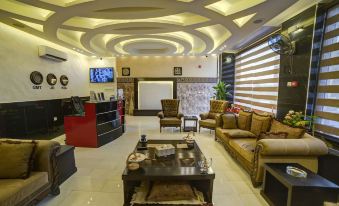 a spacious , well - decorated living room with various furniture , including a couch , chairs , and a television at Taj Hotel