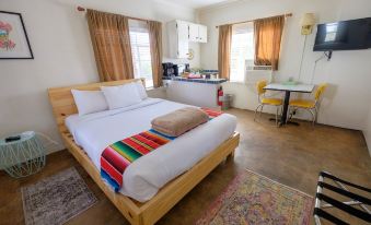 a cozy bedroom with a wooden bed , white sheets , and a colorful rug on the floor at Antelope Lodge