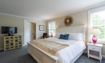 a large bed with a white headboard and footboard is in a room with gray carpet at The Homestead
