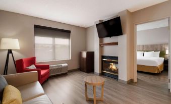 a cozy living room with a fireplace and a flat - screen tv mounted on the wall at Country Inn & Suites by Radisson, Harrisburg Northeast - Hershey