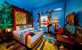 a colorful bedroom with a bed , dresser , and chair , as well as a surfboard on the wall at Legoland® Florida Resort
