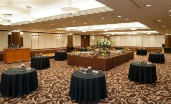 a large room with a circular table in the center and tables with black tablecloths at Nagoya Tokyu Hotel