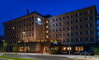 "a large , modern hotel building with the name "" four points by sheraton "" on top , illuminated at night" at Doubletree by Hilton Brescia
