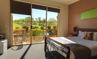 a bedroom with a large bed and sliding glass doors leading to an outdoor patio at De'Vine Escape