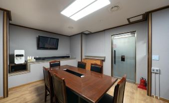 a conference room with a wooden table , chairs , and a tv mounted on the wall at Symphony Hotel