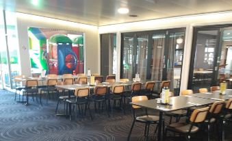 a large dining room with multiple tables and chairs arranged for a group of people to enjoy a meal together at Peppermill Inn Motel