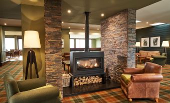 a cozy living room with a fireplace , a couch , and a rug on the floor at Isle of Mull Hotel and Spa