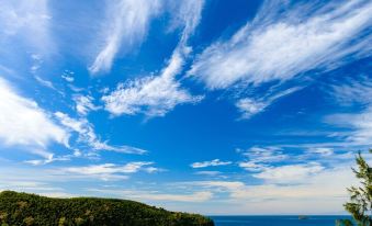 a beautiful beach scene with clear blue water , white sandy shore , and a cloudy sky at Mantaray Island Resort