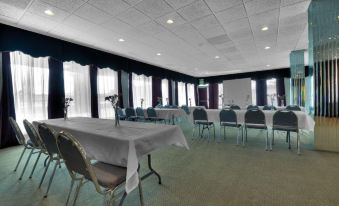 a conference room with tables , chairs , and a large window , ready for meetings or presentations at Silver Beach Hotel