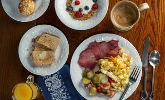 a wooden table with a variety of breakfast foods , including eggs , bacon , toast , and fruit salad at Justin Trails Resort