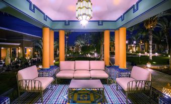 a living room with a pink couch , blue and orange patterned floor , and a chandelier at Sol Oasis Marrakech - All Inclusive