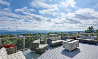 a rooftop patio with a fire pit surrounded by couches and chairs , overlooking the city at Home2 Suites by Hilton Dickson City Scranton