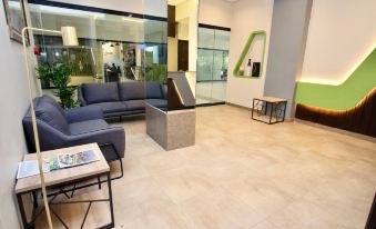 a modern office lobby with a couch , chairs , and a coffee table , as well as a large window providing natural light at Sukro