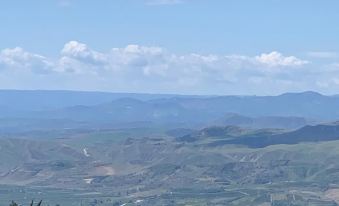 a scenic view of a valley with mountains in the background and a blue sky above at The Lux