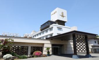 "a large white hotel building with a sign that reads "" hida hotel "" prominently displayed on the front" at Hotel Fuji