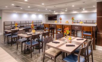 a large dining room with multiple tables and chairs arranged for a group of people to enjoy a meal together at Holiday Inn Belcamp - Aberdeen Area