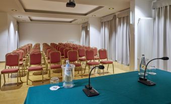 a conference room with rows of chairs arranged in a semicircle , and a podium at the front of the room at Grand Hotel Misurina