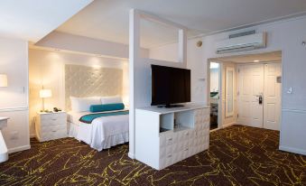 a modern bedroom with a large bed and a flat - screen tv mounted on the wall at The Roslyn, Tapestry Collection by Hilton