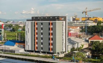 a modern apartment building with orange accents and large windows , situated in a bustling city environment at NAP in Fest