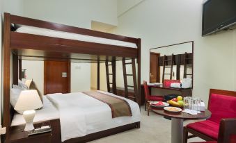 a large bed with a ladder is in a room with chairs , a dining table , and a mirror at Ras Al Jinz Turtle Reserve