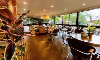 a large , well - lit restaurant with multiple dining tables and chairs arranged in an open space at Quest Breakfast Creek
