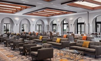 a large , modern hotel lobby with multiple couches and chairs arranged in an open space at Hyatt Regency Huntington Beach Resort and Spa