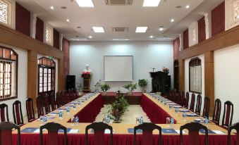 a large conference room with multiple tables , chairs , and a screen , set up for a meeting or event at A member of Saigontourist Group