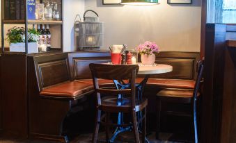a cozy corner of a restaurant with a table , chairs , and a bottle of wine at Bischoffs