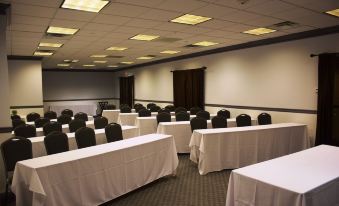 a large conference room with rows of tables and chairs arranged for a meeting or event at Southampton Inn