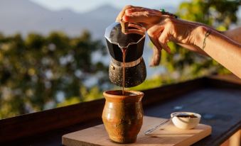 a person is pouring a liquid from a pitcher into a cup on a wooden table at Eagle's Retreats