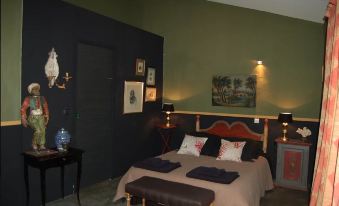 a cozy bedroom with a large bed and a variety of decorative items , such as paintings and vases at Casa Montes