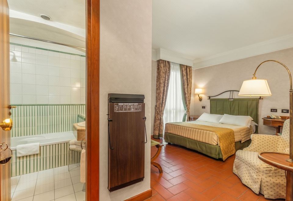 a hotel room with a king - sized bed , a bathtub , and a bathroom with a shower at Hotel Ristorante la Pergola